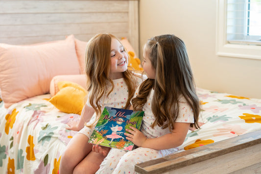 Two girls in Chloe the Ballerina Mouse pajamas reading the matching Pima Bee storybook